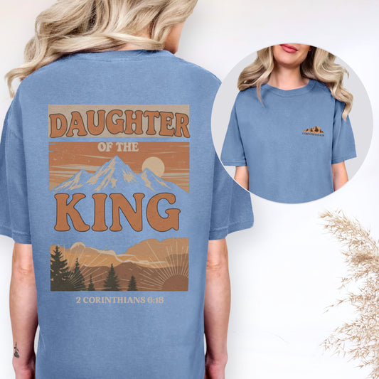 Blue t-shirt with 'Daughter of the King' design on the back, worn by a person.