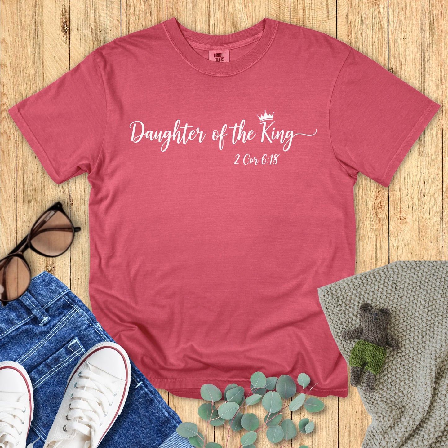 Crimson t-shirt with white script reading “Daughter of the King – 2 Cor 6:18” accented by a small crown design.