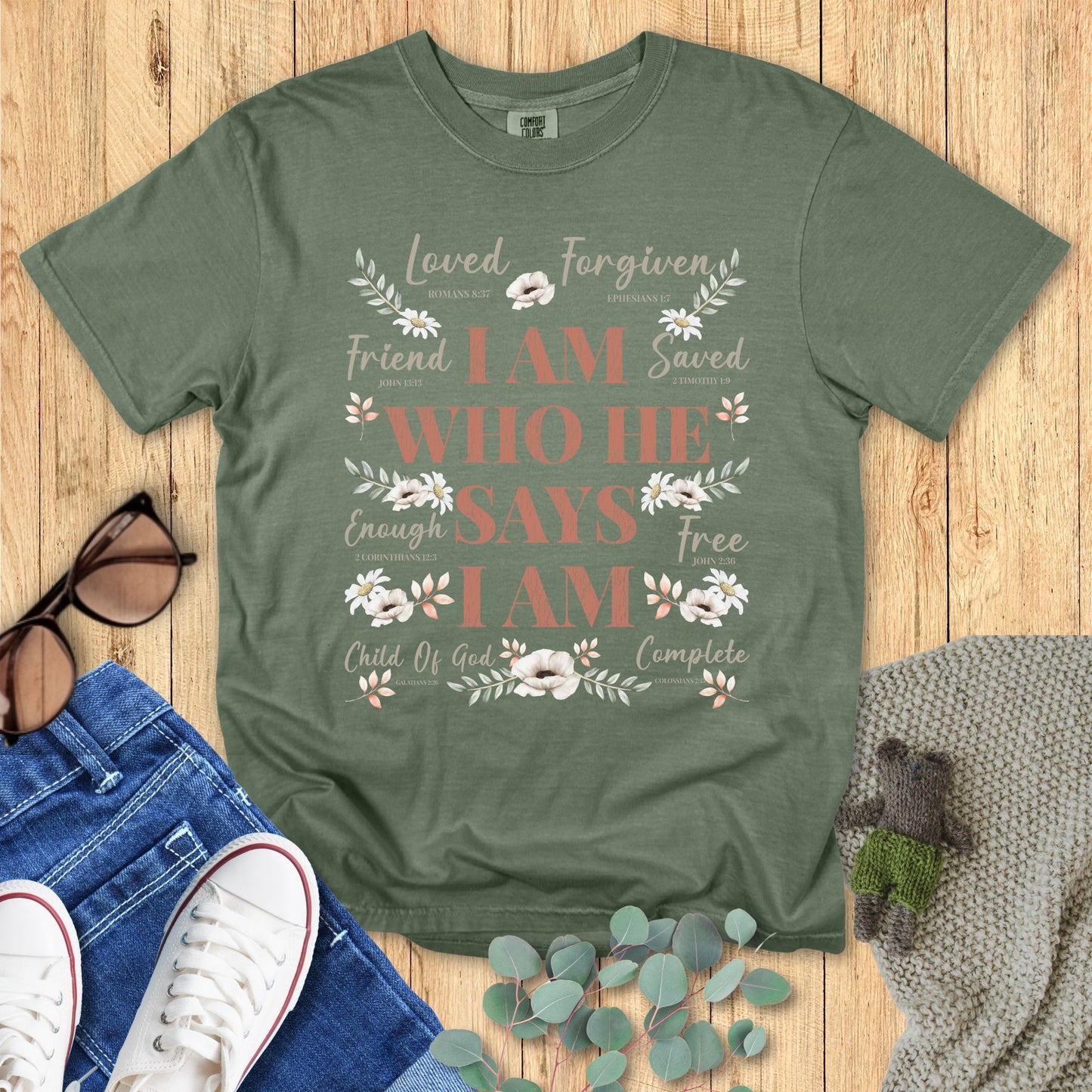 Green t-shirt with motivational text on a wooden surface with accessories.