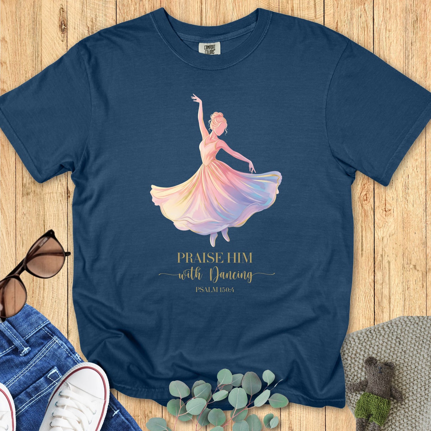 Comfort Colors 1717 Christian women t-shirt in midnight navy flat lay. Christian design shows a ballerina in a flowing rainbow dress with text “Praise Him with Dancing – Psalm 150:4