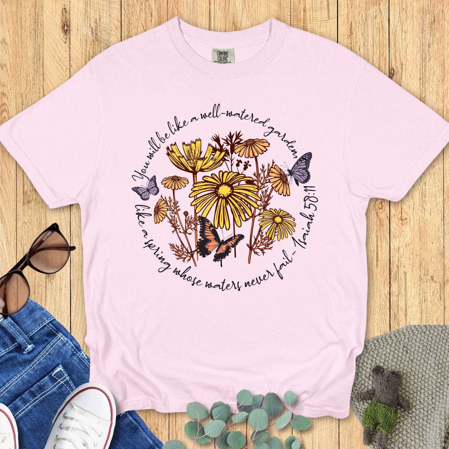 Christian Comfort Colors 1717 T-shirt in blossom pink with the same floral and butterfly scripture design, styled with casual flat lay props.