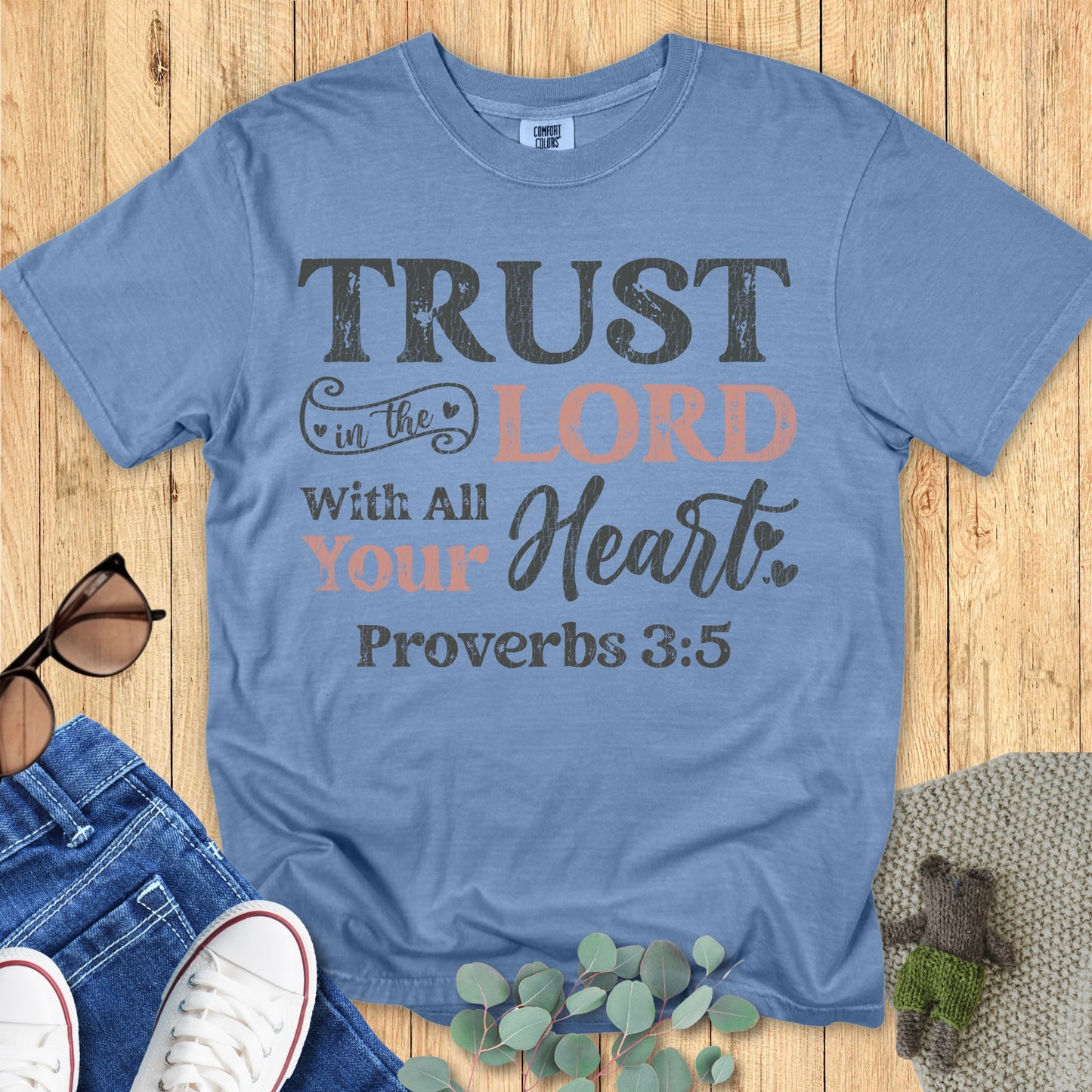 Comfort Colors 1717 blue jean “Trust in the Lord with all your heart – Proverbs 3:5” t-shirt featuring distressed lettering in black and blush tones. A stylish women’s scripture tee — encouraging modern Christian shirt and meaningful faith-based apparel for women.