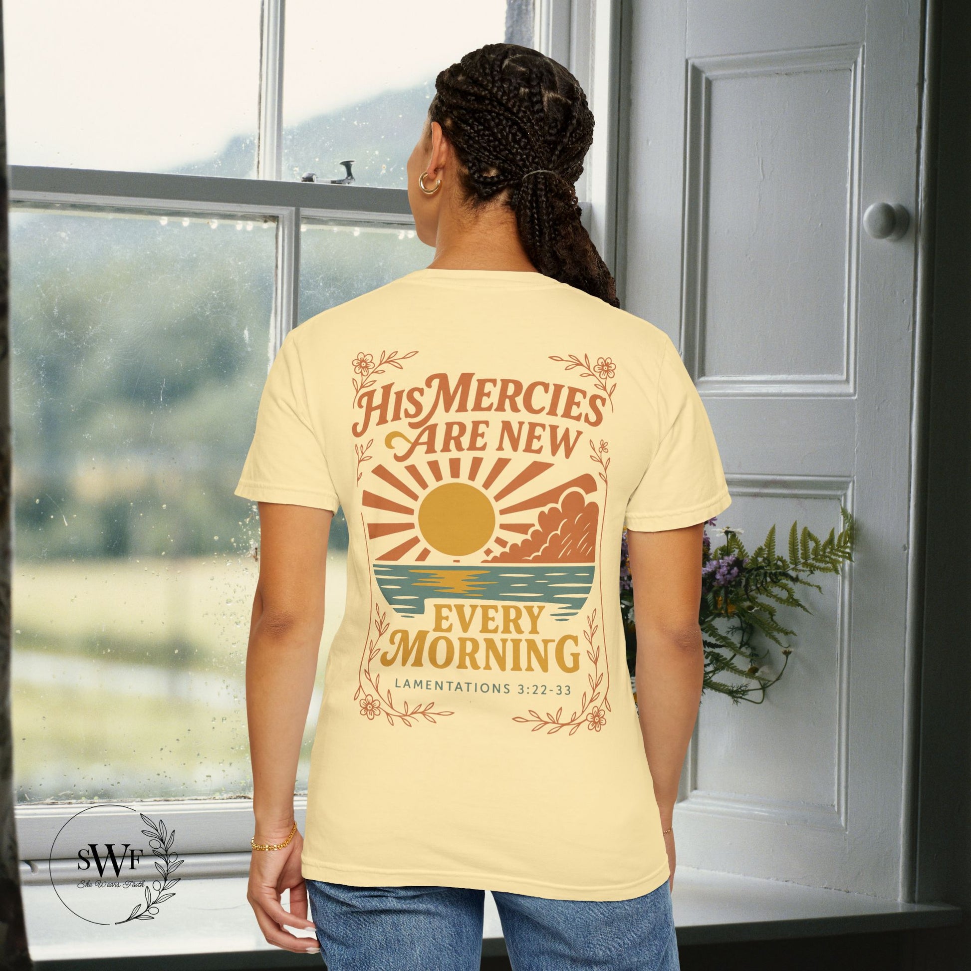 Back view of a banana yellow Christian women’s tee with warm-toned sunrise artwork and the phrase “His Mercies Are New Every Morning – Lamentations 3:22–33.”