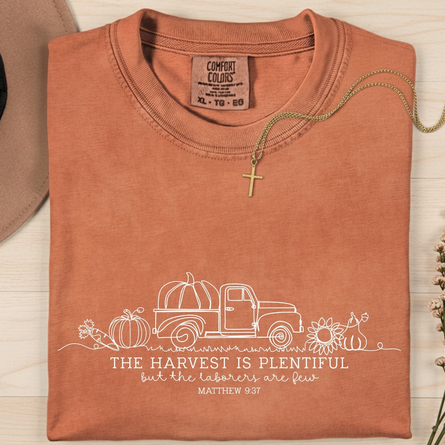 Folded Comfort Colors 1717 yam “The harvest is plentiful but the laborers are few” t-shirt (Matthew 9:37) with simple fall decor. A warm women’s scripture tee - faith-based apparel for women and modern Christian shirt, meaningful Christian mom gift idea inspired by harvest blessings.