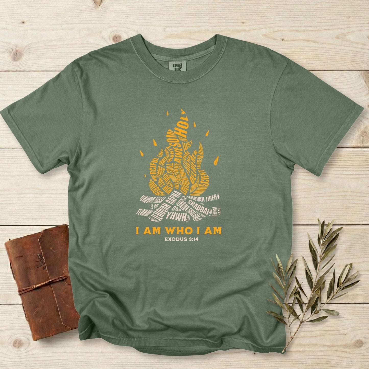 Christian women tee with “I Am Who I Am” Exodus 3:14 flame design printed on Comfort Colors 1717 tshirt in Moss green. Minimal yet bold US faith wear featuring biblical typography and vintage-inspired Christian artwork.