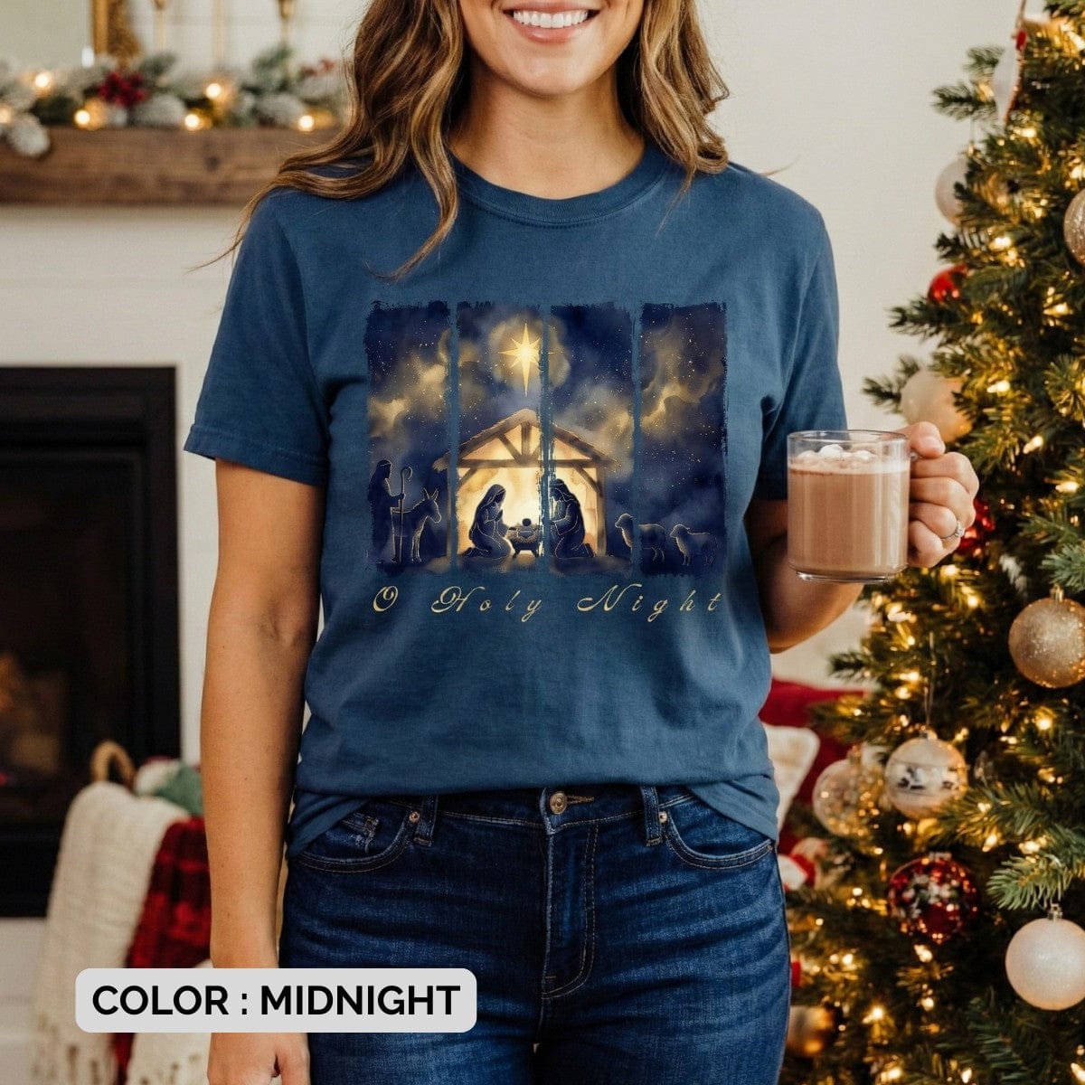 lifestyle model of women wearing Comfort Colors 1717 midnight Christian T-shirt displaying a rich watercolor “O Holy Night” manger scene with the Holy Family, shepherds, and glowing star. A beautiful Christmas US faith wear tee arranged with rustic holiday décor.