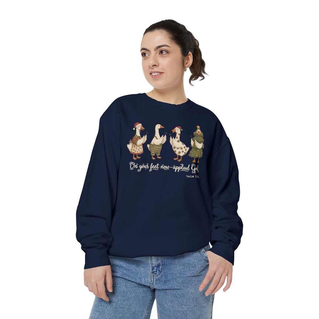 Christian Christmas sweatshirt with four geese in Santa hats and Christmas outfits clapping above On your feet now, applaud God and Psalm 100:1.
