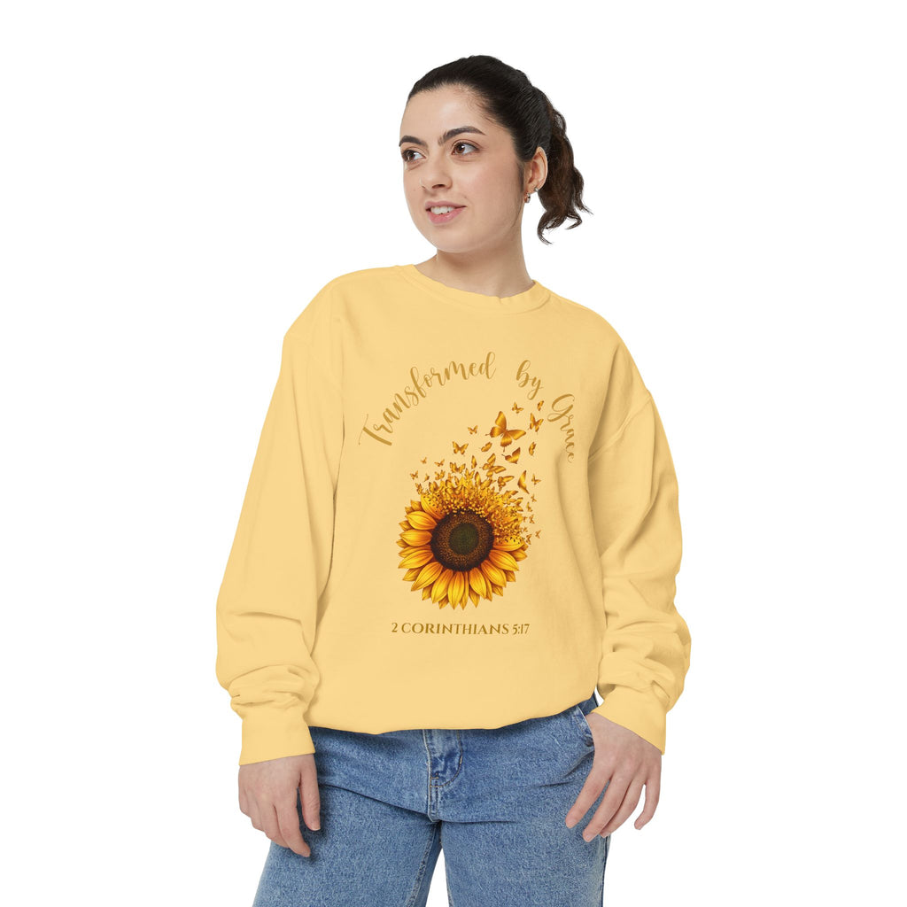 Christian sweatshirt with a painted sunflower whose petals turn into butterflies, reading Transformed by Grace, 2 Corinthians 5:17