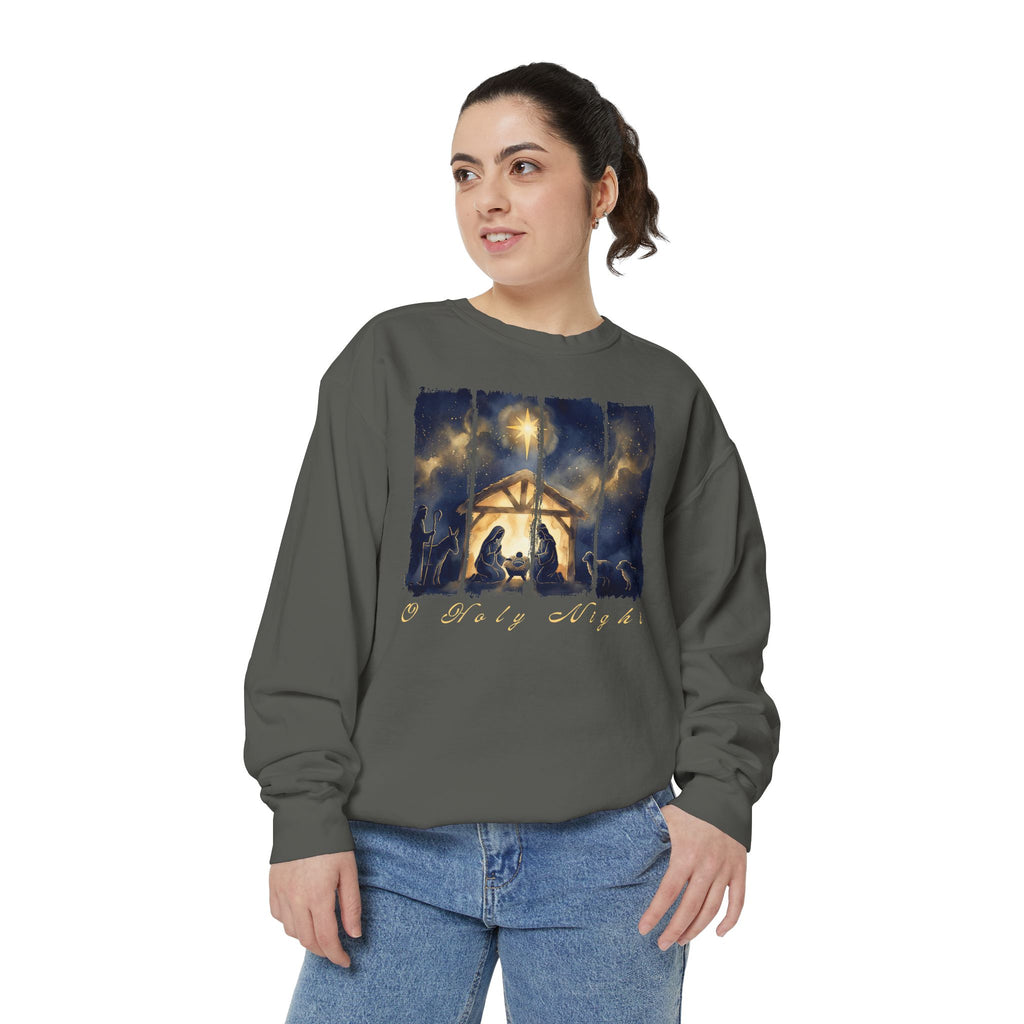 Pepper Christian Christmas sweatshirt with a painted nativity of Mary, Joseph and the manger in a glowing stable under a bright star, with O Holy Night in script.