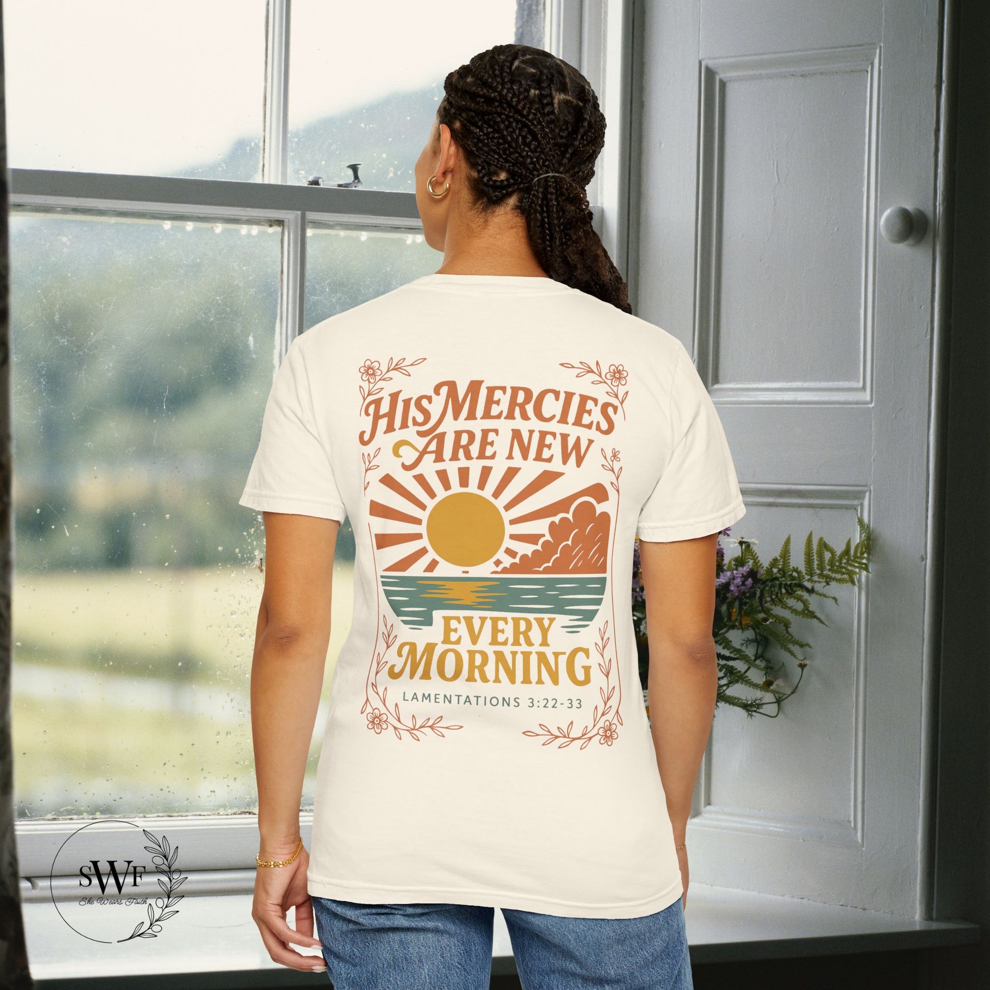 Back view of an ivory Christian women’s t-shirt with a retro sunrise design and the words “His Mercies Are New Every Morning – Lamentations 3:22–33.”