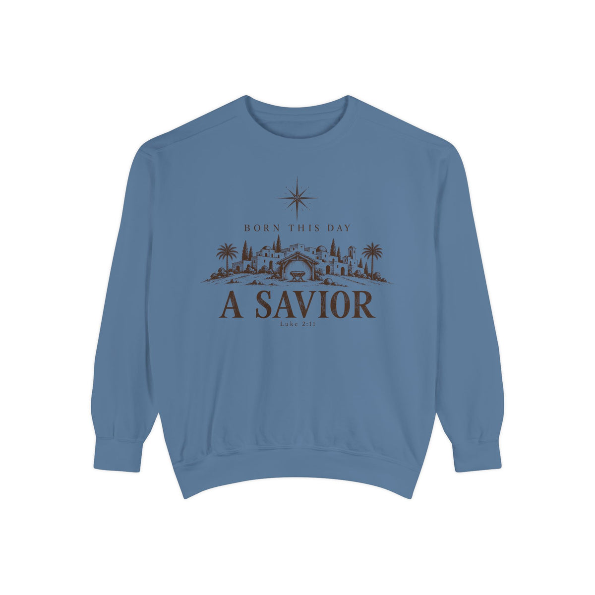 Blue Jean Christian Christmas sweatshirt with Born This Day A Savior lettering, a star over a Bethlehem town scene, a manger and Luke 2:11.