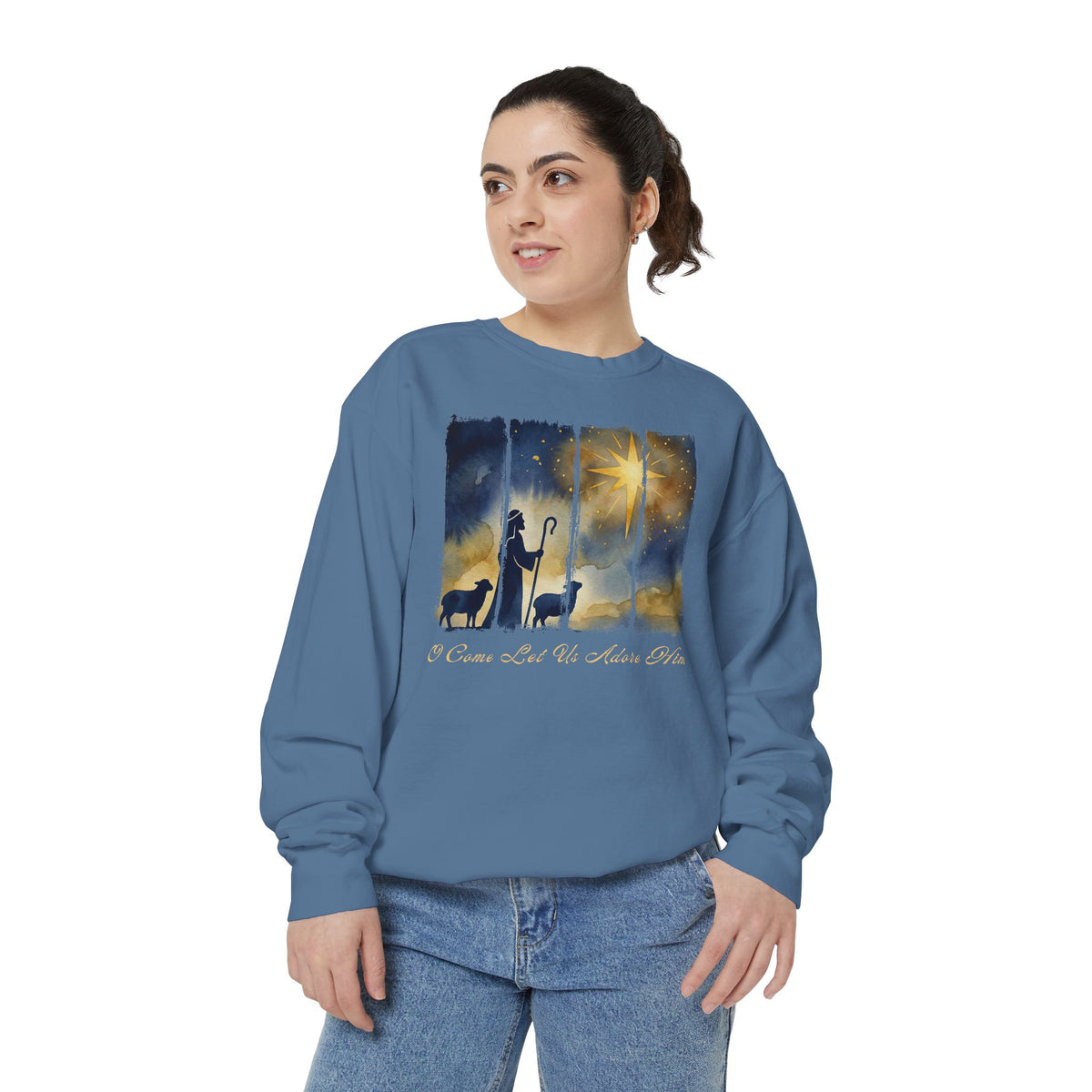 Christian Christmas sweatshirt with a painted shepherd and two sheep under a golden star and O Come Let Us Adore Him in script.