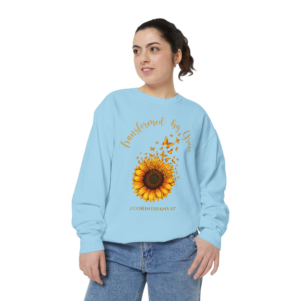 Christian sweatshirt with a painted sunflower whose petals turn into butterflies, reading Transformed by Grace, 2 Corinthians 5:17