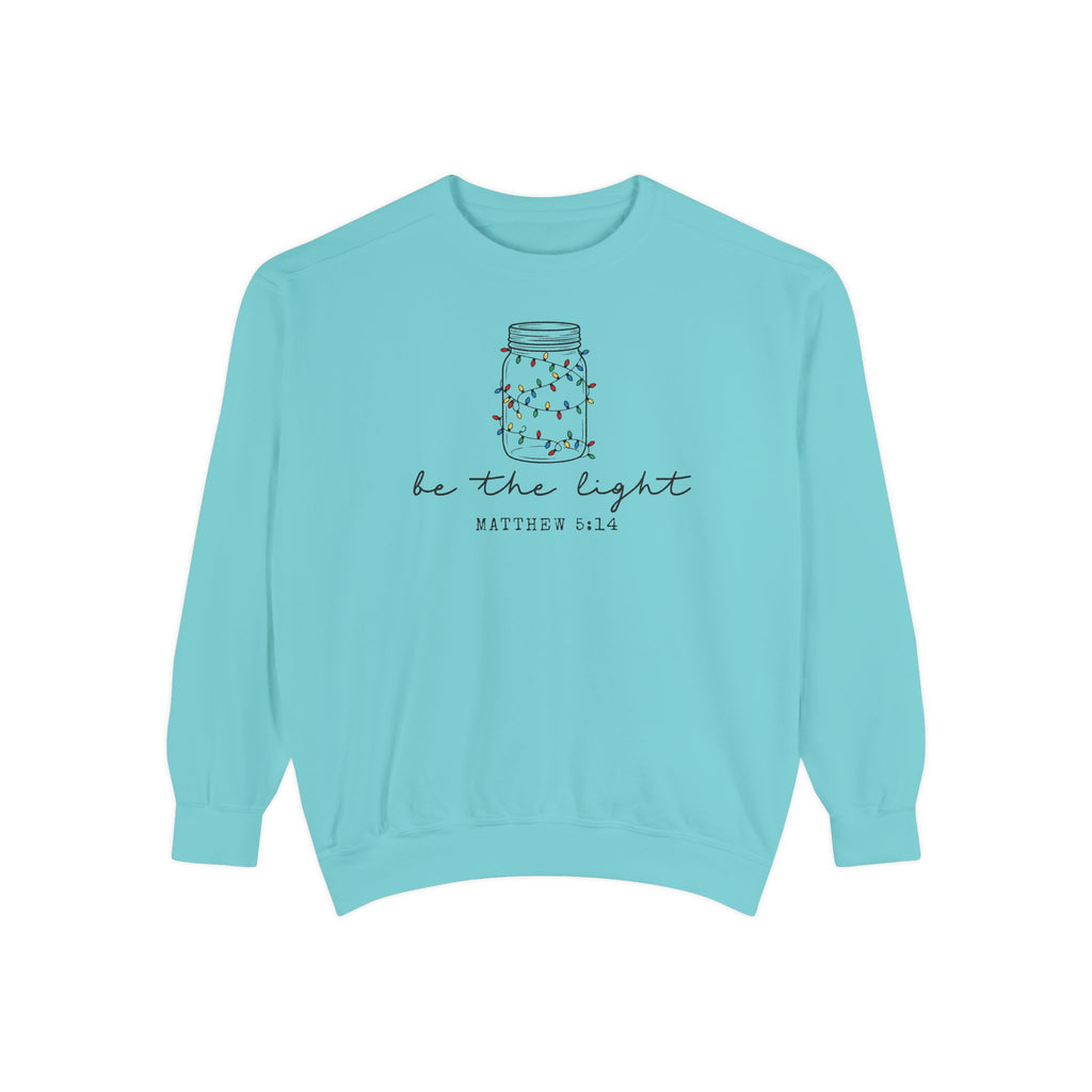 Chalky Mint Christian Christmas sweatshirt with a mason jar wrapped in Christmas lights, be the light script and Matthew 5:14.