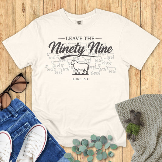 Ivory White t-shirt with text and graphics on a wooden surface with accessories.