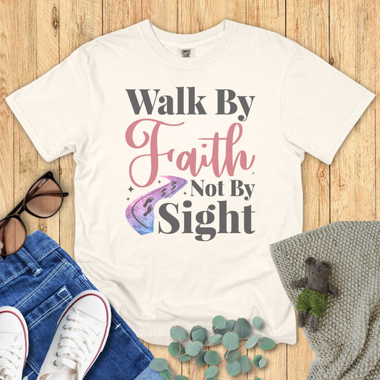 Ivory White t-shirt with 'Walk By Faith Not By Sight' text on a wooden surface with accessories.