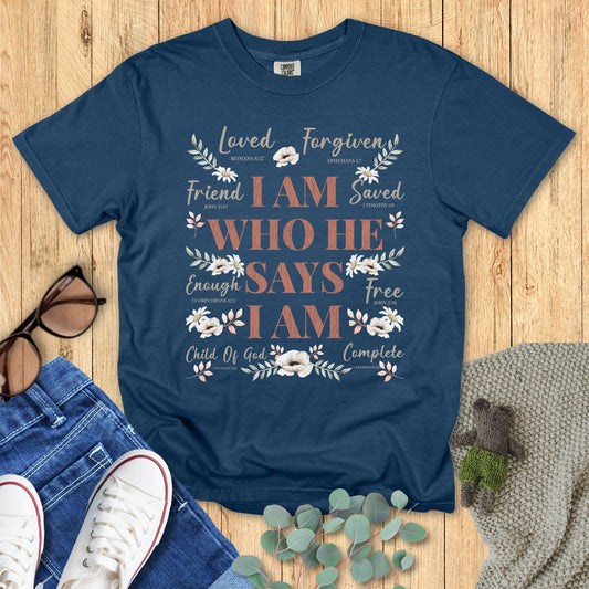 Blue t-shirt with motivational text design on a wooden surface with accessories.
