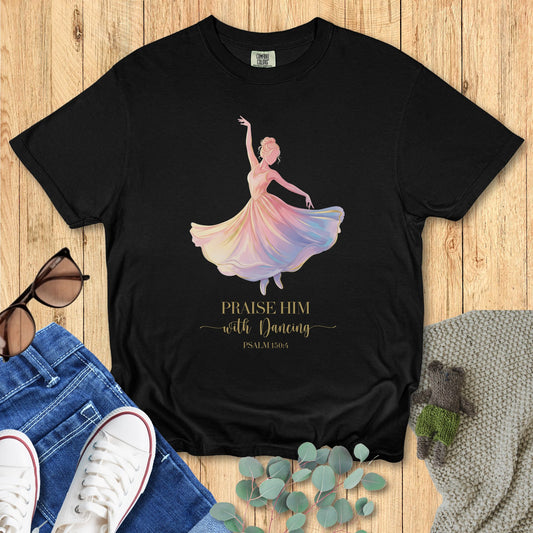 Black t-shirt with a colorful dancing figure and text on a wooden surface with accessories.