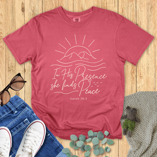 Red t-shirt with motivational quote on a wooden surface with accessories.