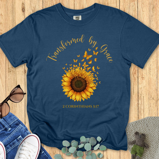 Comfort Colors 1717 Christian women t-shirt in midnight navy flat lay. Faith-based sunflower and butterfly design with the phrase “Transformed by Grace – 2 Corinthians 5:17