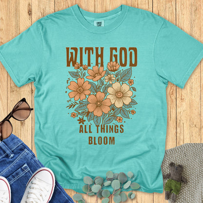 Christian women’s Comfort Colors 1717 t-shirt in Seafoam featuring peach floral artwork and text that reads ‘With God All Things Bloom.’ Shown in a styled flat lay with casual accessories