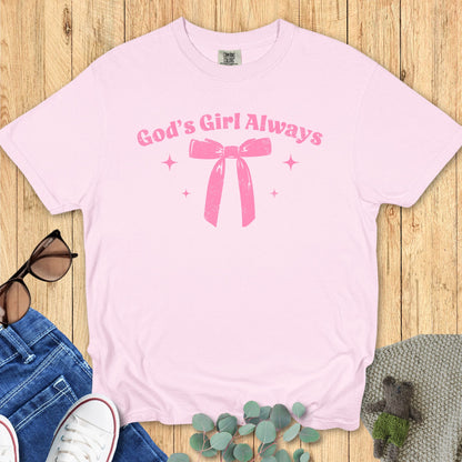 lat lay of a light pink T-shirt featuring the same “God’s Girl Always” pink bow and sparkles design.
