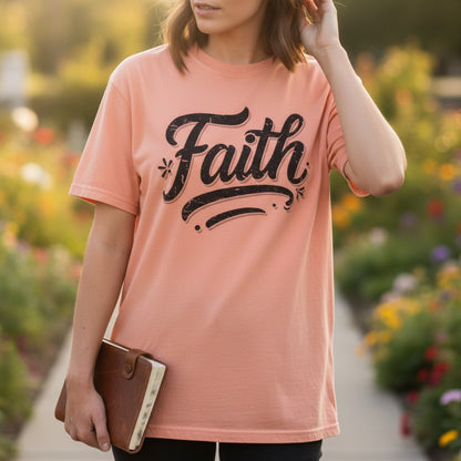 Woman holding a Bible while wearing a Comfort Colors 1717 terracotta “Faith” t-shirt in a garden at sunset. A warm and uplifting women’s scripture tee inspired by 2 Corinthians 5:7 t-shirt, perfect for daily wear or Christian mom gift ideas.
