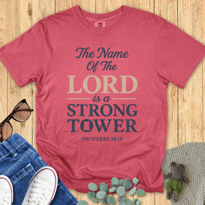 Comfort Colors 1717 crimson “The Name of the Lord is a Strong Tower – Proverbs 18:10” t-shirt flatlay styled with casual denim outfit. A bold and uplifting women’s scripture tee, great as a Christian mom gift idea.