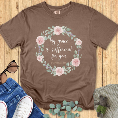 Flatlay of a Comfort Colors 1717 espresso “My Grace Is Sufficient for You – 2 Corinthians 12:9” t-shirt featuring a soft floral wreath design. A beautiful women’s scripture tee and meaningful Christian mom gift idea.