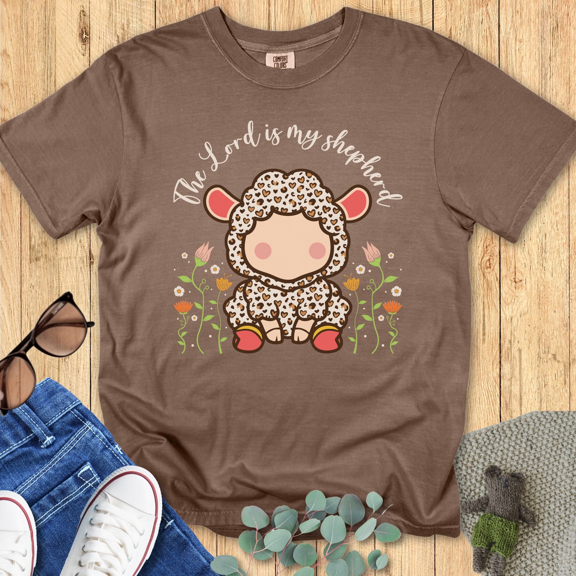 Comfort Colors 1717 espresso “The Lord Is My Shepherd” t-shirt with a cute lamb design in a floral field. A cozy and meaningful piece of faith-based apparel for women and a thoughtful modern Christian shirt gift.