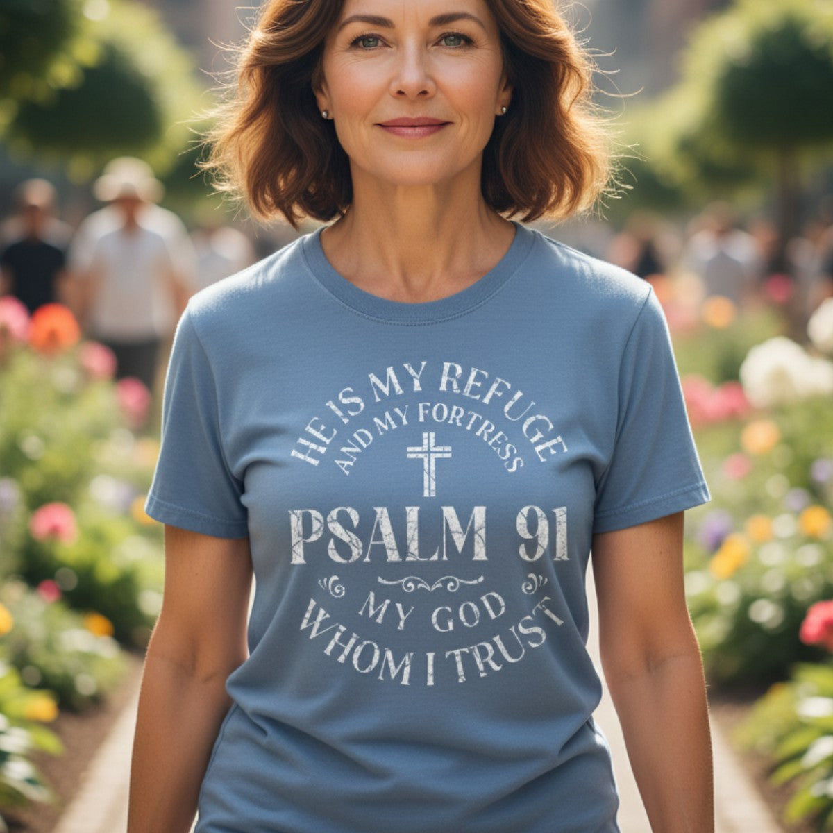 Smiling woman outdoors wearing a Comfort Colors 1717 blue jean “He Is My Refuge and My Fortress – Psalm 91 My God Whom I Trust” t-shirt. A modern Christian shirt expressing strength and trust in God — elegant women’s scripture tee and Christian mom gift idea.