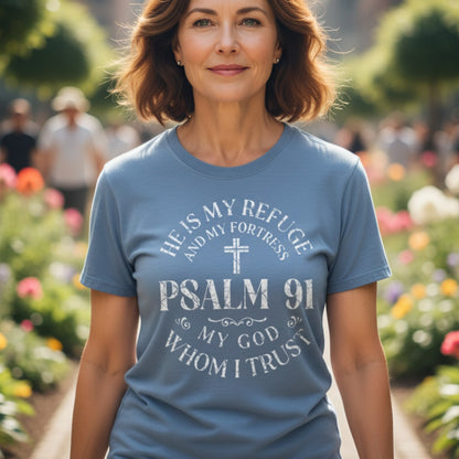 Smiling woman outdoors wearing a Comfort Colors 1717 blue jean “He Is My Refuge and My Fortress – Psalm 91 My God Whom I Trust” t-shirt. A modern Christian shirt expressing strength and trust in God — elegant women’s scripture tee and Christian mom gift idea.