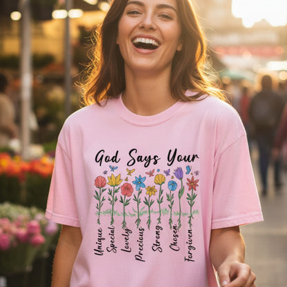 Joyful woman walking outdoors wearing a Comfort Colors 1717 blossom “God Says You Are” t-shirt with a colorful floral affirmation design. A radiant and encouraging women’s scripture tee — perfect modern Christian shirt and heartwarming Christian mom gift idea.