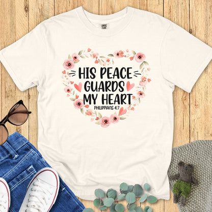 Comfort Colors 1717 ivory “His Peace Guards My Heart – Philippians 4:7” t-shirt with a delicate heart of watercolor-style roses and leaves. A calming modern Christian shirt — beautiful women’s scripture tee and heartfelt Christian mom gift idea.