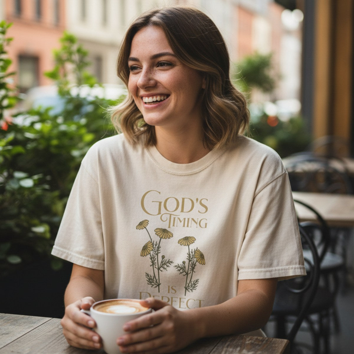 Smiling woman enjoying coffee in a Comfort Colors 1717 ivory “God’s Timing Is Perfect – Ecclesiastes 3:11” t-shirt. A serene and encouraging women’s scripture tee — soft modern Christian shirt and uplifting faith-based apparel for women, perfect Christian mom gift.