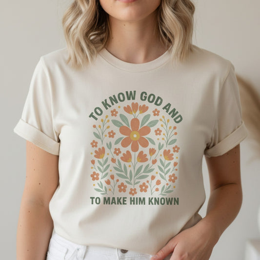 Woman wearing a Comfort Colors 1717 ivory βTo Know God and To Make Him Knownβ t-shirt with a floral faith design. A soft and uplifting womenβs scripture tee β faith-based apparel for women and modern Christian shirt, thoughtful Christian mom gift idea.