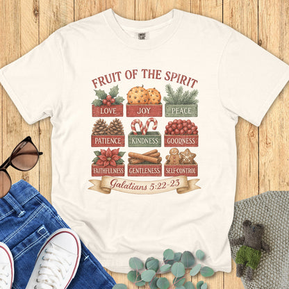 Flatlay of a Comfort Colors 1717 ivory “Fruit of the Spirit” t-shirt displaying a vintage Christmas-themed design with the nine fruits listed in Galatians 5:22–23. A timeless women’s scripture tee — faith-based apparel for women and modern Christian shirt, beautiful Christian mom gift idea.
