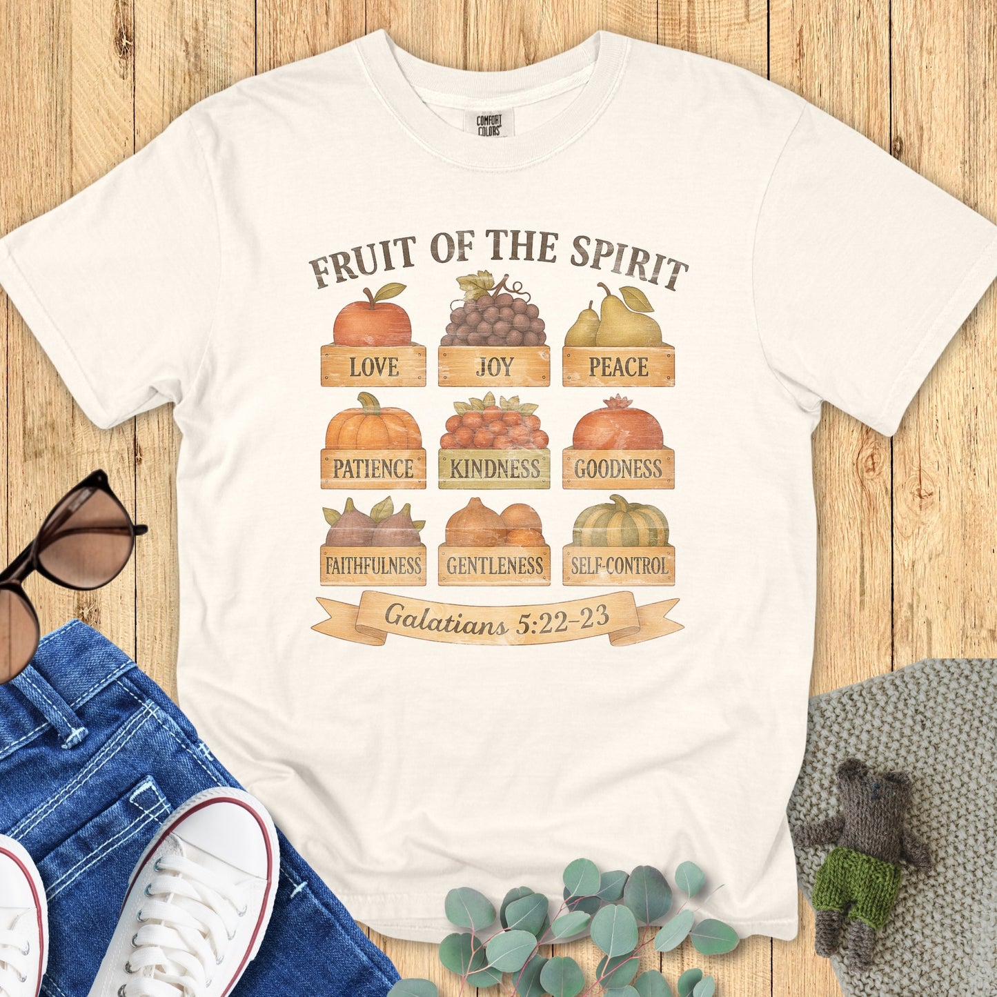 Flatlay of a Comfort Colors 1717 ivory “Fruit of the Spirit” t-shirt featuring a rustic fall harvest design inspired by Galatians 5:22–23. A vintage-style women’s scripture tee — faith-based apparel for women and modern Christian shirt, meaningful Christian mom gift idea.