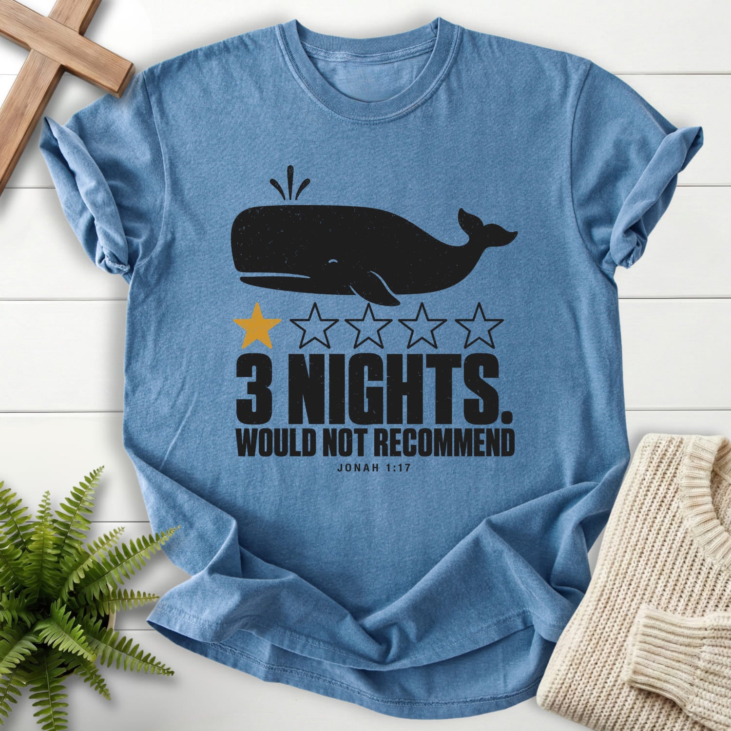 Flatlay of a Blue Jean women's Christian tee with minimal whale artwork with "3 Nights Jonah 1 17 Dark T-Shirt".
