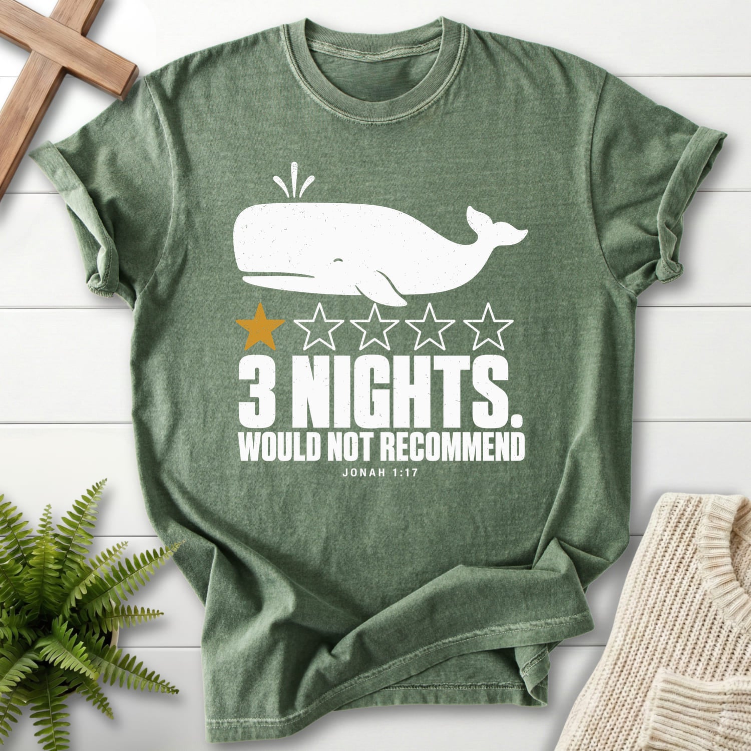 Flatlay of a Moss Christian t-shirt for women with minimal whale artwork with "3 Nights Jonah 1 17 Dark T-Shirt".