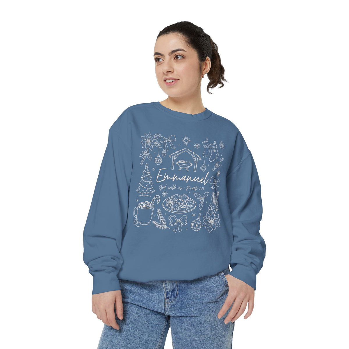 Christian Christmas sweatshirt with Emmanuel God with us script and Matthew 1:23 surrounded by doodles of a manger, stockings, a tree, cocoa and cookies.