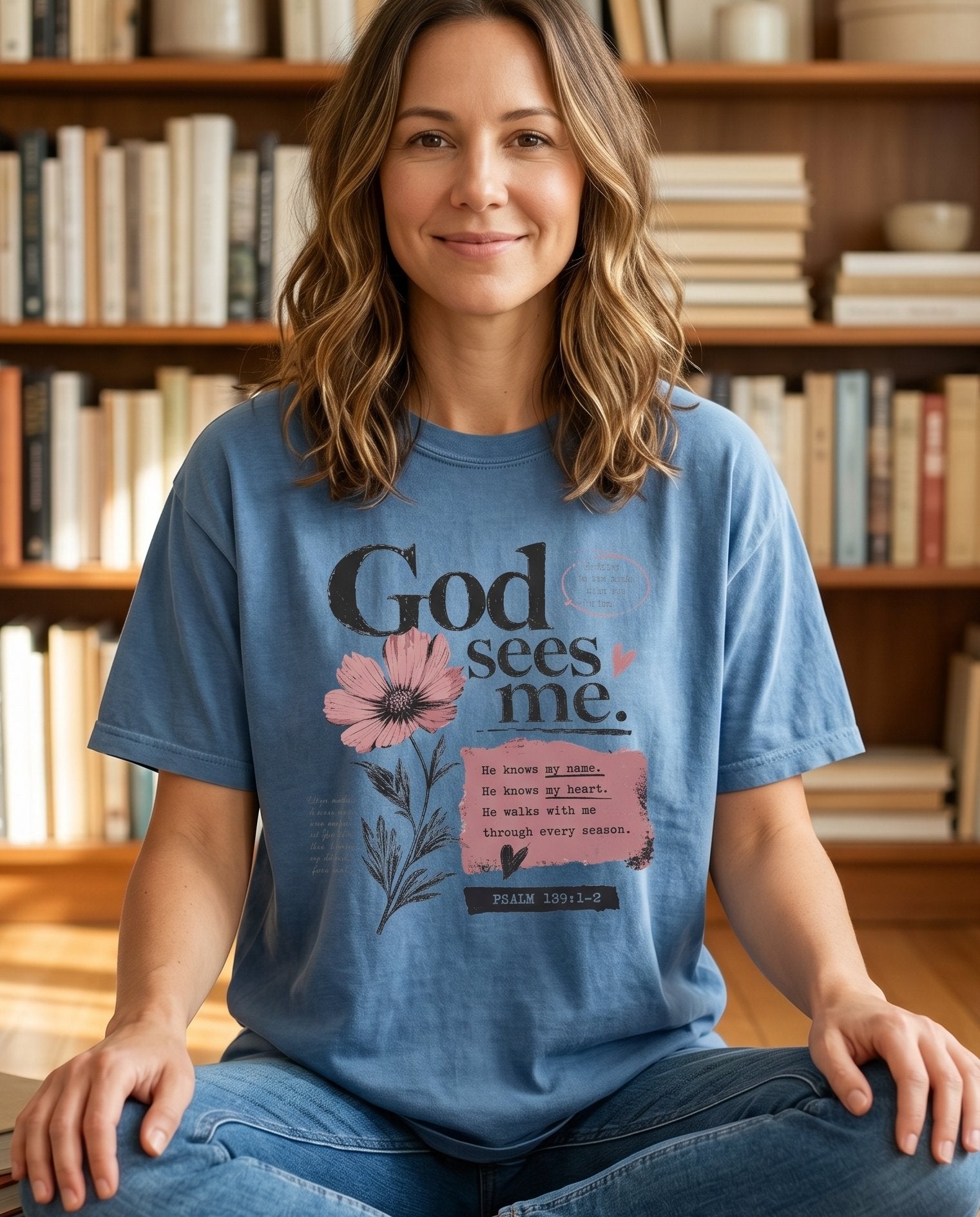 God Sees Me – Blue Jean women's Christian tee, lifestyle photo in cozy reading nook – God Sees Me Hagar wilderness refuge shelter comfort scripture faith – She Wears Faith