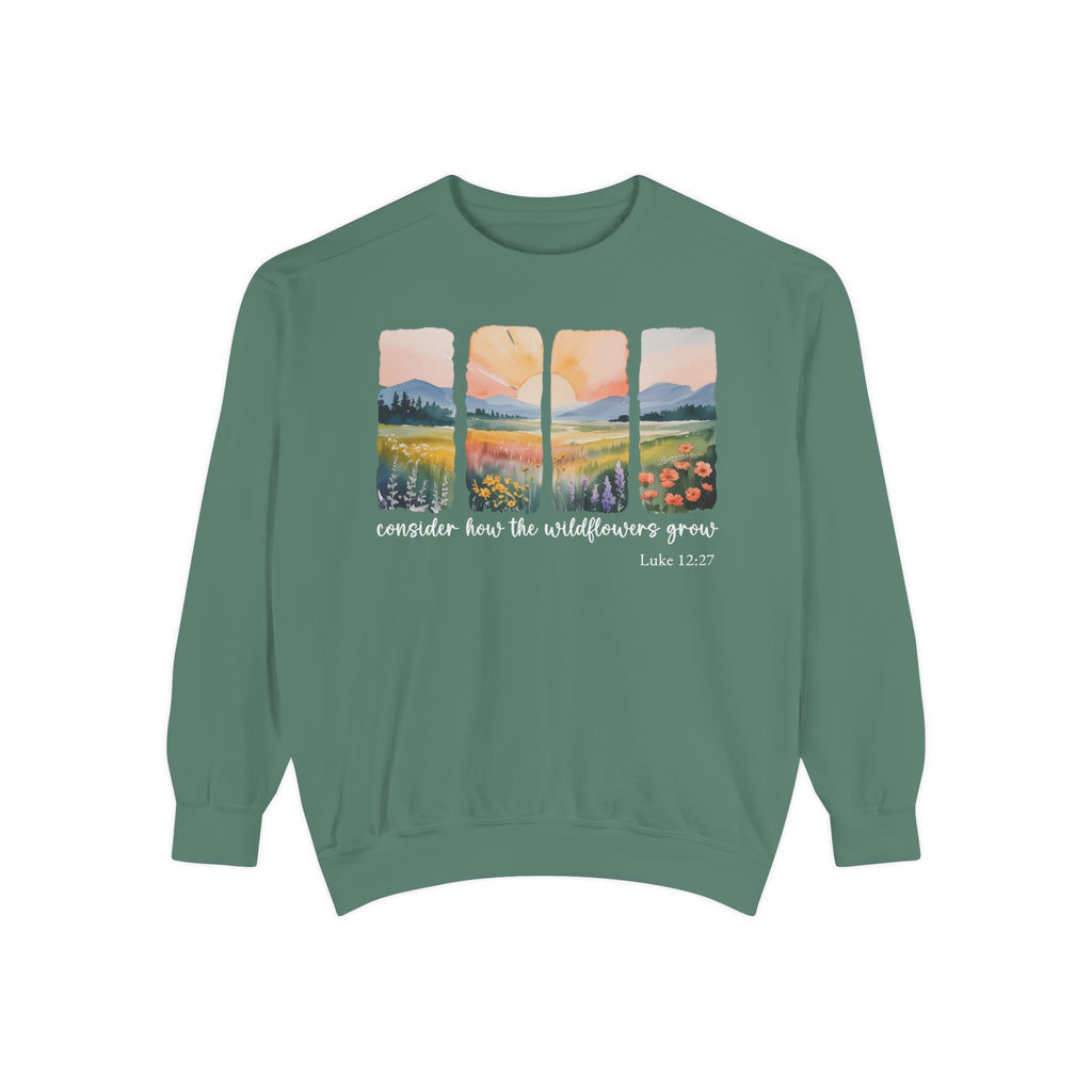 Light Green Christian sweatshirt with four painted panels of sunrise over hills and a wildflower meadow, reading consider how the wildflowers grow, Luke 12:27