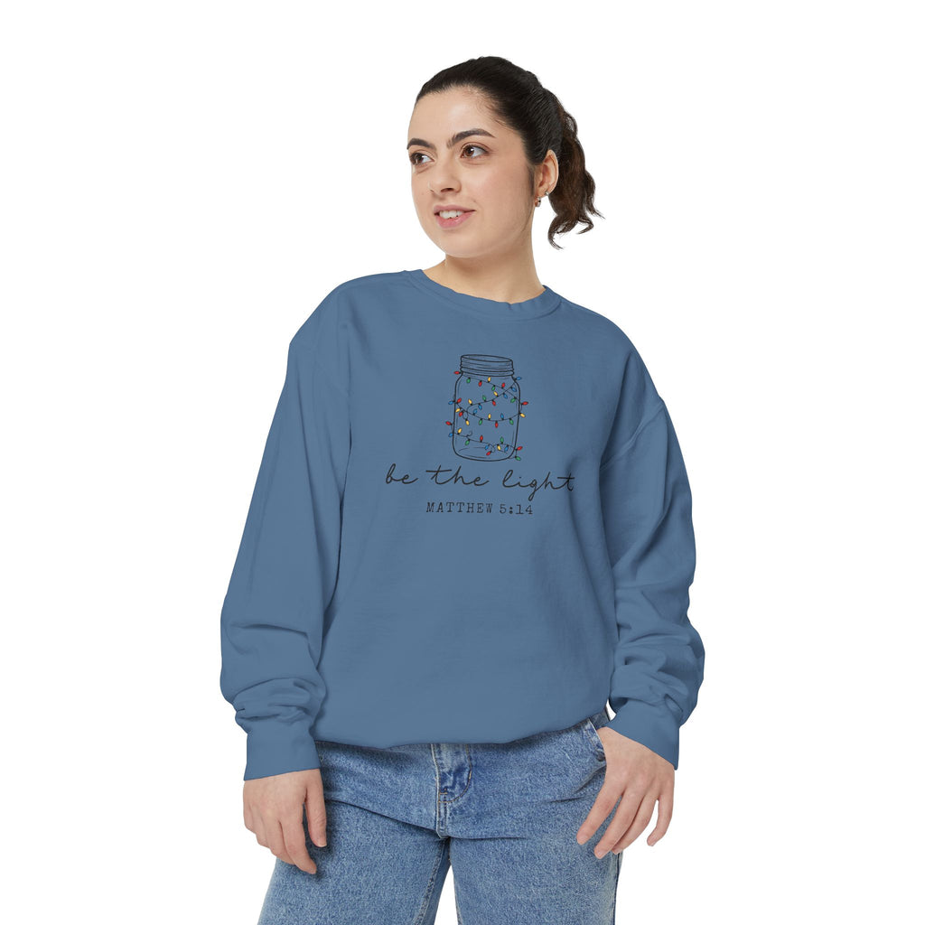 Christian Christmas sweatshirt with a mason jar wrapped in Christmas lights, be the light script and Matthew 5:14.