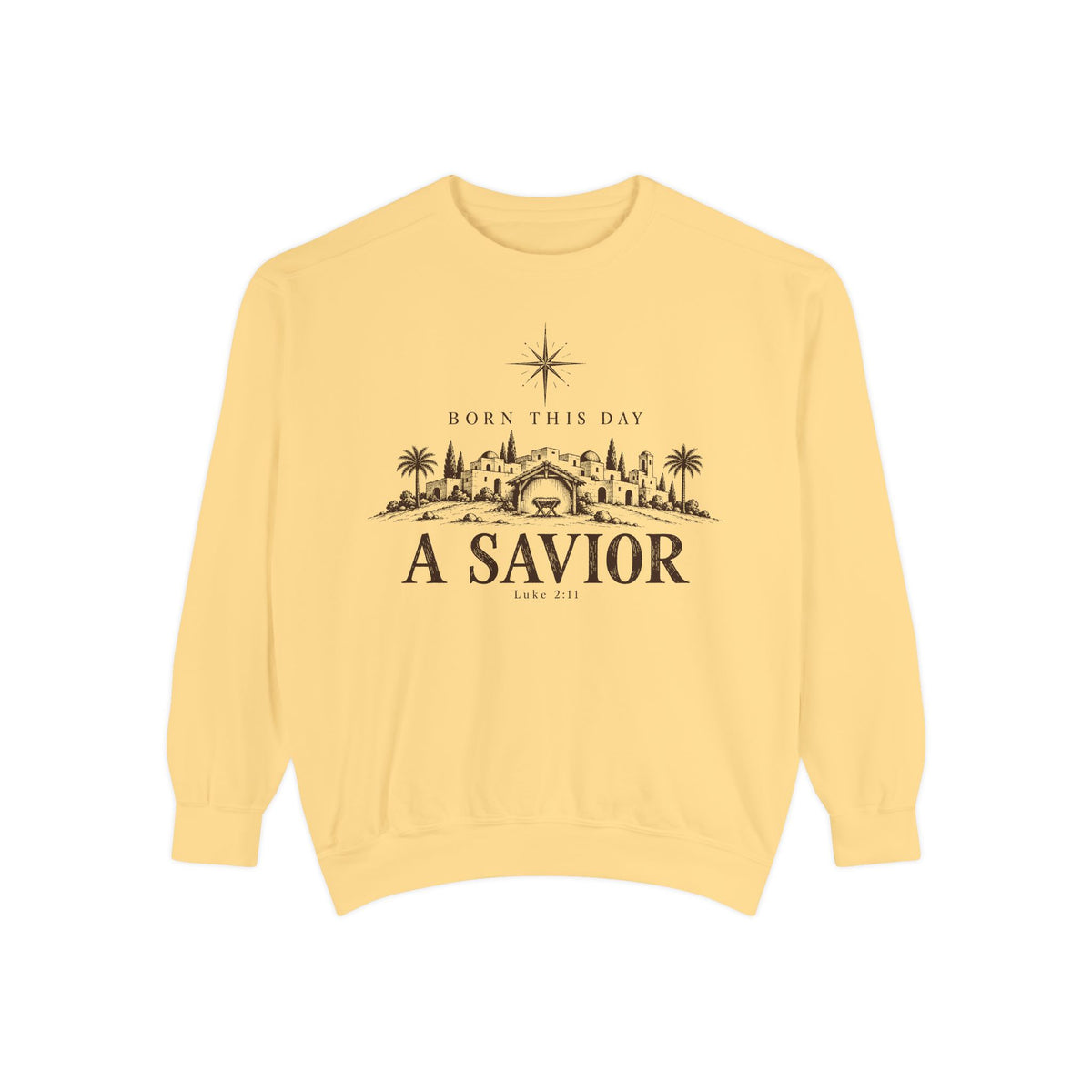 Butter Christian Christmas sweatshirt with Born This Day A Savior lettering, a star over a Bethlehem town scene, a manger and Luke 2:11.