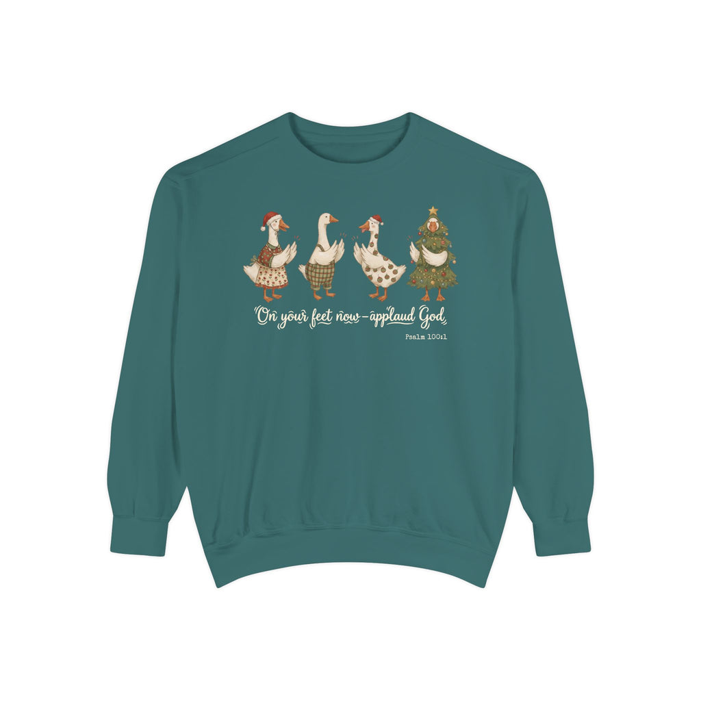 Christian Christmas sweatshirt with four geese in Santa hats and Christmas outfits clapping above On your feet now, applaud God and Psalm 100:1.