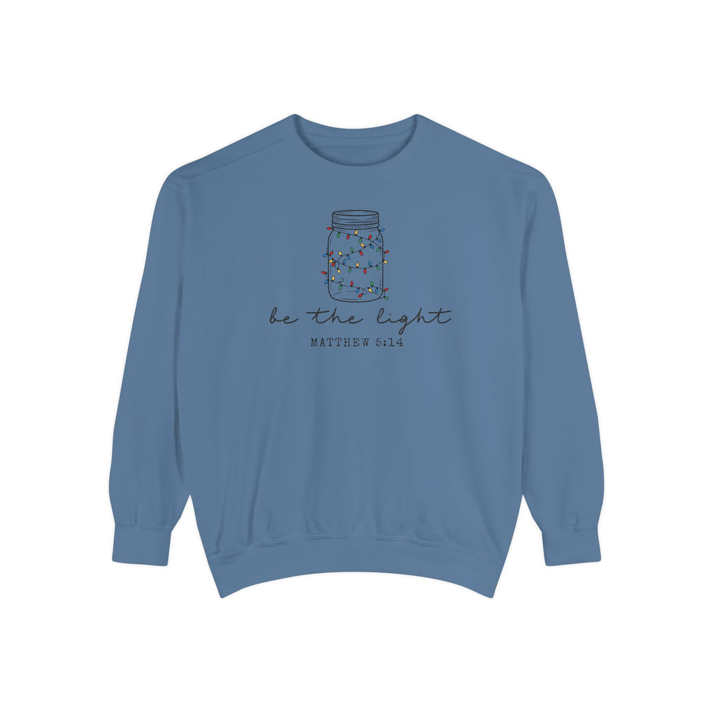 Blue Jean Christian Christmas sweatshirt with a mason jar wrapped in Christmas lights, be the light script and Matthew 5:14.