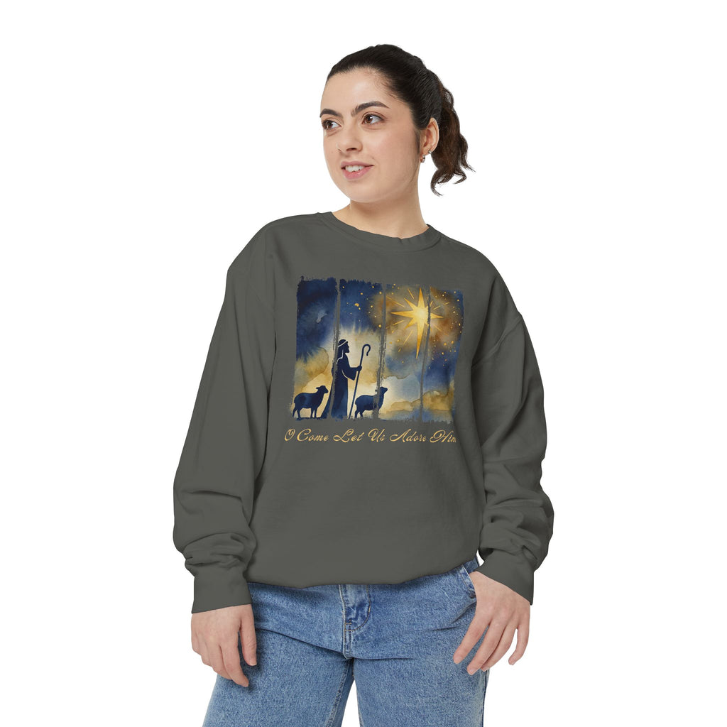 Christian Christmas sweatshirt with a painted shepherd and two sheep under a golden star and O Come Let Us Adore Him in script.