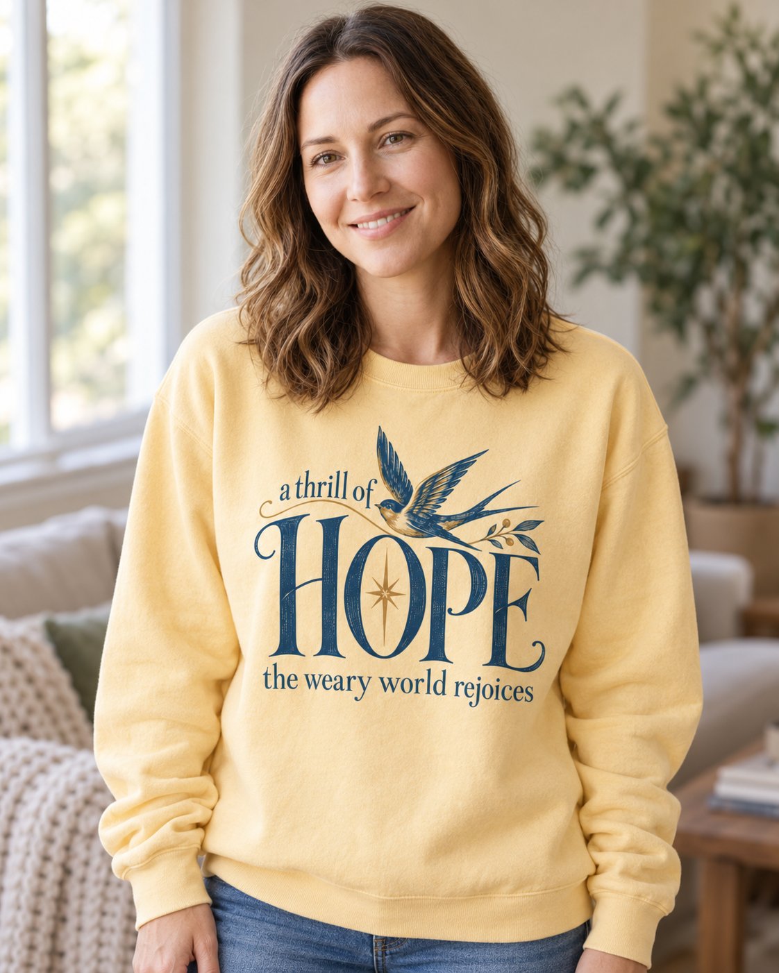 A Thrill of Hope, Butter women's Christian sweatshirt, lifestyle photo in cozy living room, Navy dove and star above HOPE with the weary world rejoices, She Wears Faith