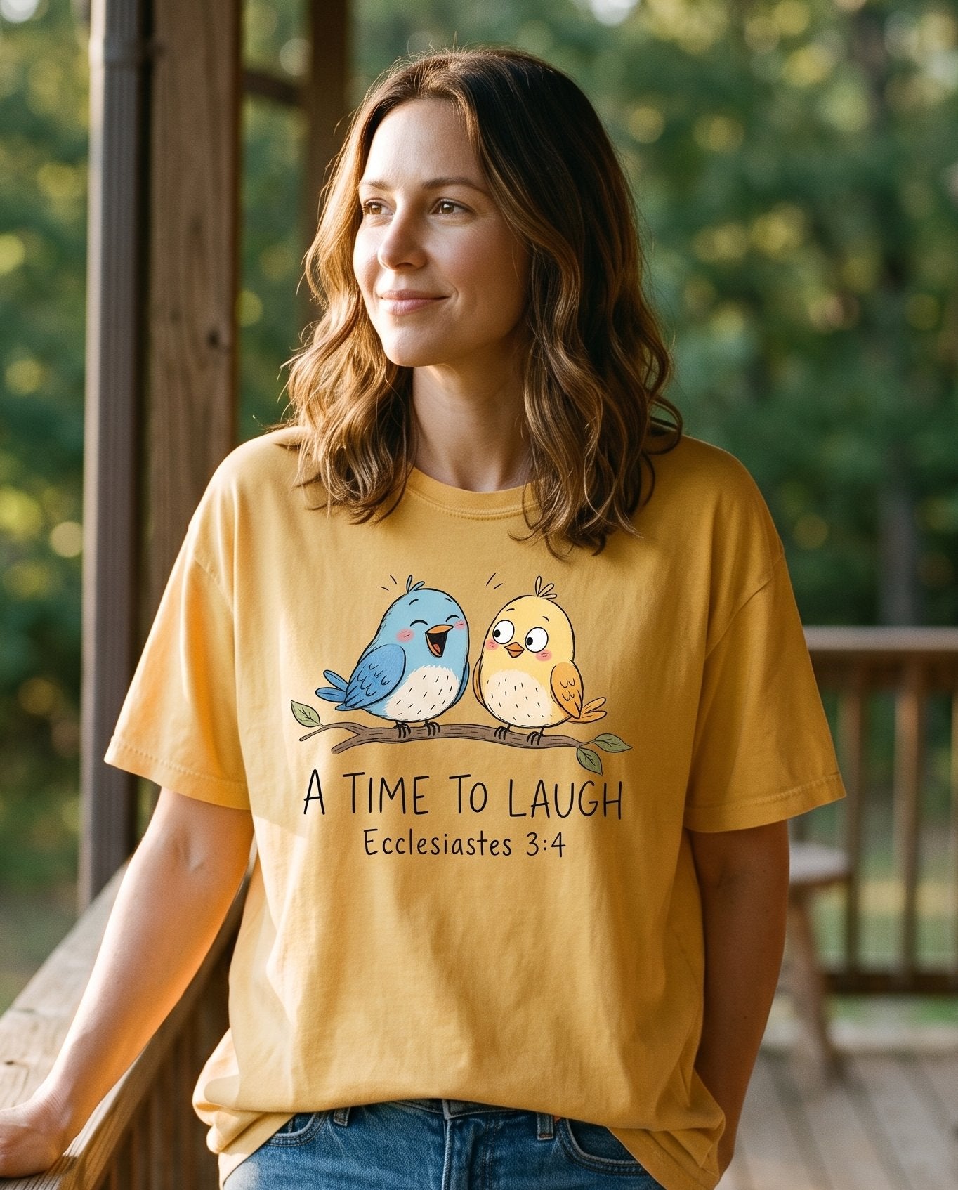 A Time To Laugh Faith Birds – Mustard women's Christian tee, lifestyle photo in sunny porch – Two cartoon birds on a branch – Ecclesiastes 3:4 – She Wears Faith